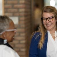 woman in blue blazer chats with woman in white sweater